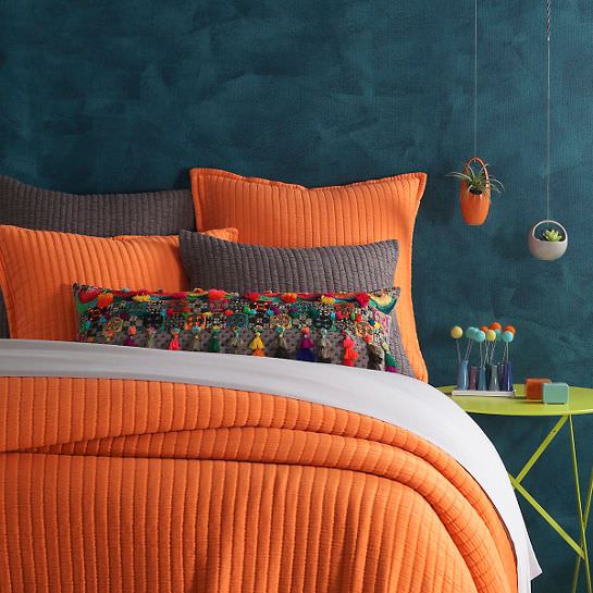 اتاق خواب با کاغذ دیواری سرمه ای و روتختی نارنجی