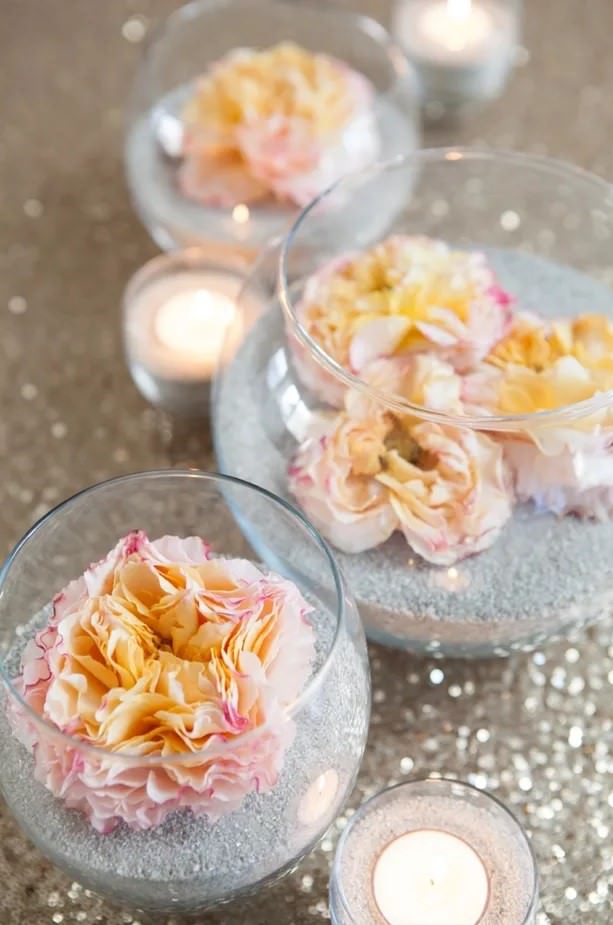 استفاده از ماسه و شن برای تزیین ظرف شیشه ای تنگی با گل مصنوعی