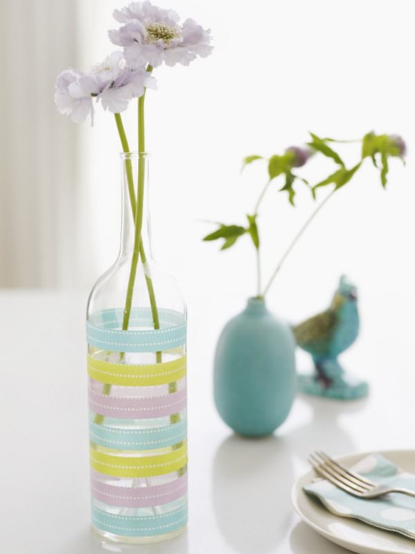 ظرف شیشه ای با گل مصنوعی که با چسب های تزئینی رنگی دیزاین شده است