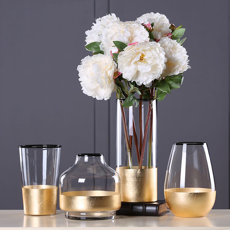 تزئین گلدان شیشه ای با گل مصنوعی که دور آن ورق طلایی چسبانده شده است