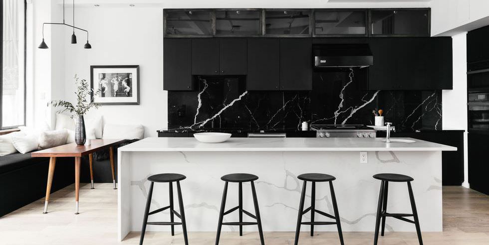 دکوراسیون سیاه و سفید آشپزخانه که کابینت ها در آن سیاه است و جزیره آن از سنگ سفید مرمر است