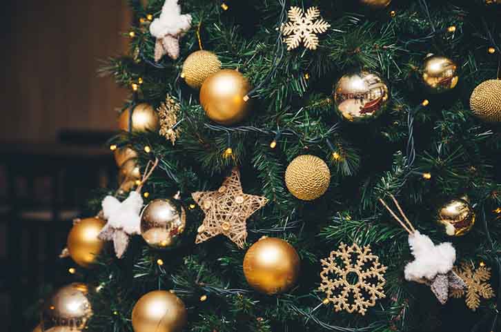 تزیین درخت کریسمس با وسایل تزئینی با تم طلایی