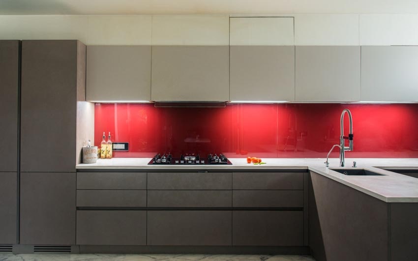 طراحی آشپزخانه مدرن و شیک با کابینت کرم و قهوه ای و بین کابینتی قرمز و صفحه پیشخوان سفید