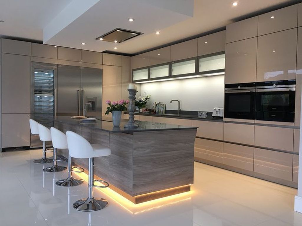 طراحی آشپزخانه مدرن و شیک با کابینت های گلاس بژ و جزیره با صندلی های سفید