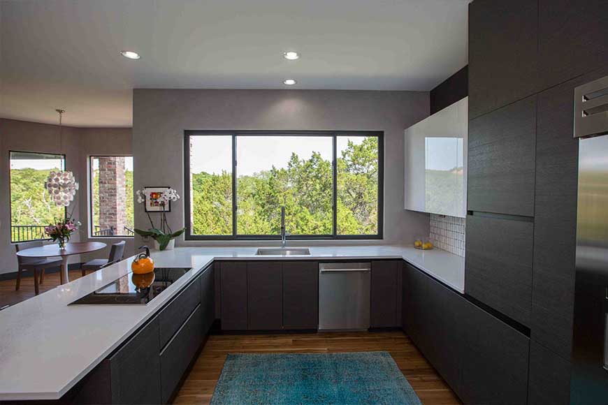 طراحی آشپزخانه مدرن و شیک با کابینت تیره قهوه ای و فرش آبی پتینه