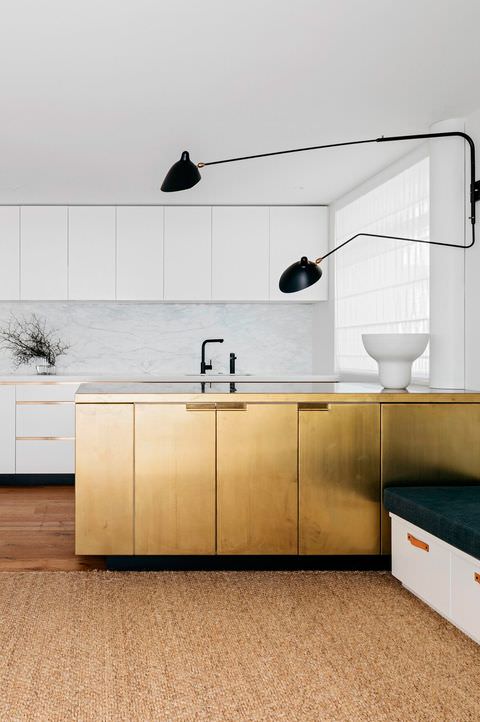 کابینت سفید طلایی در آشپزخانه مدرن با بین کابینتی سنگی سفید و شیرآلات مشکی