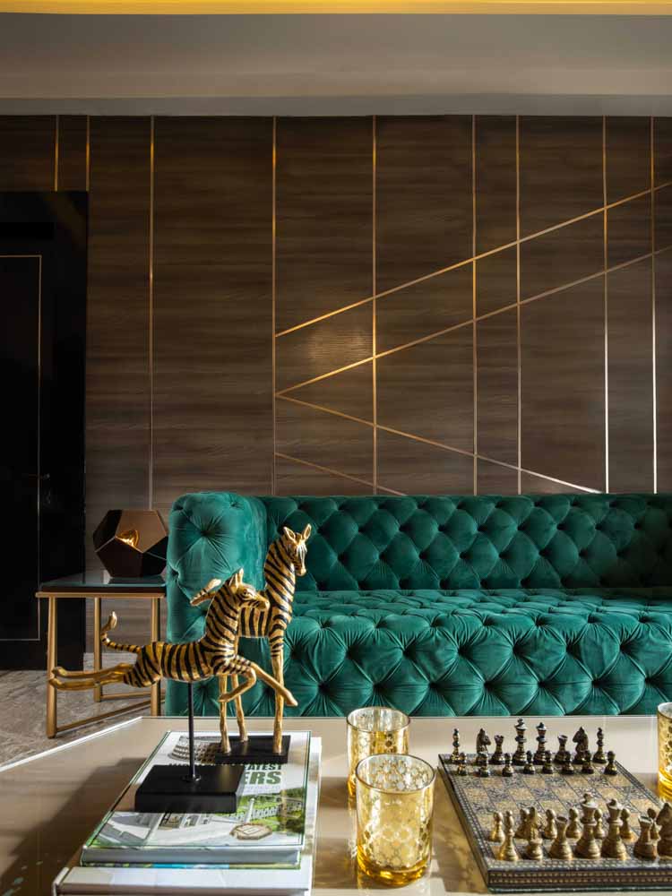 دکوراسیون قهوه ای طلایی هال و پذیرایی مدرن با مبل سبز زمردی و دیوارپوش چوبی طلایی