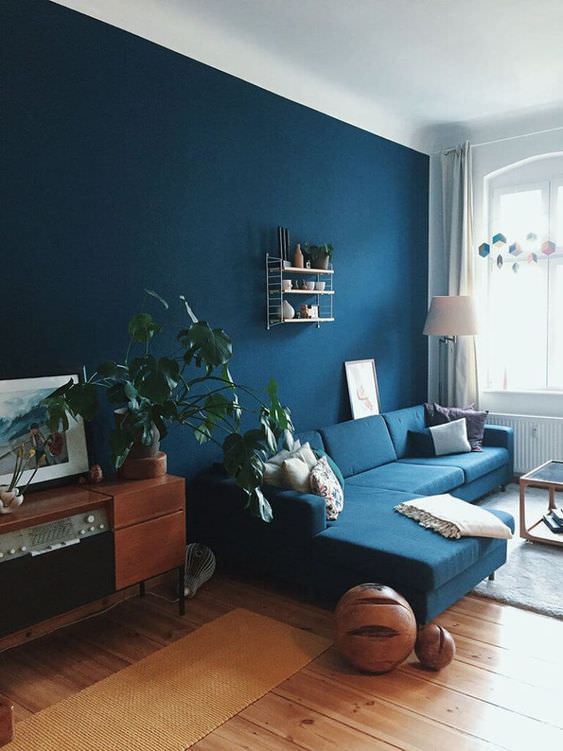دکوراسیون قهوه ای و آبی نشیمن مدرن با دیوار و مبل آبی تیره و کفپوش چوبی قهوه ای