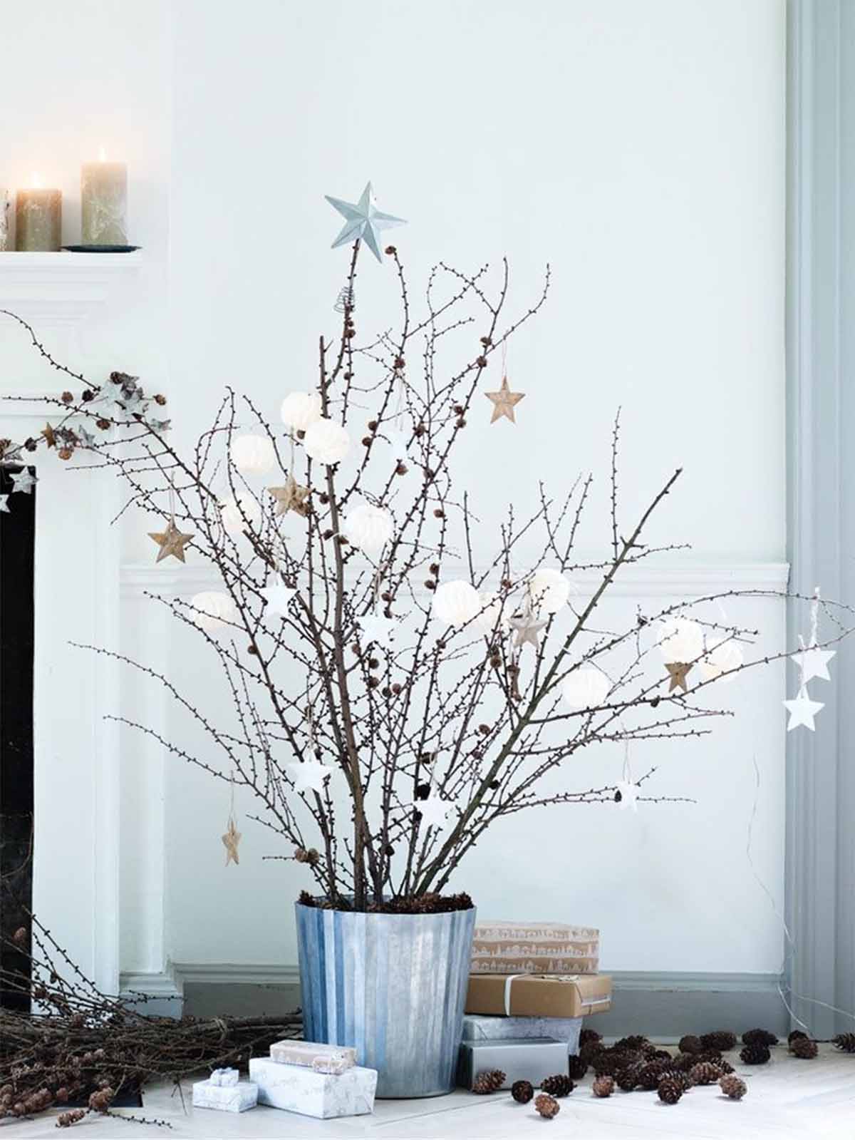 تزیین کریسمس در خانه با گلدانی از شاخه های خشک شده و میوه های درخت کاج